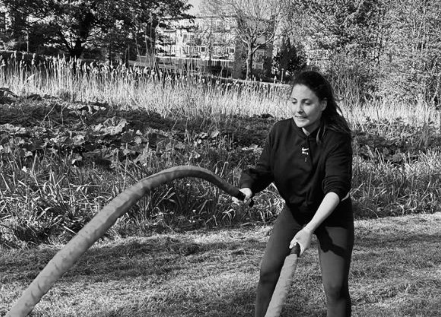 Female client battle ropes outdoor personal training Amsterdam